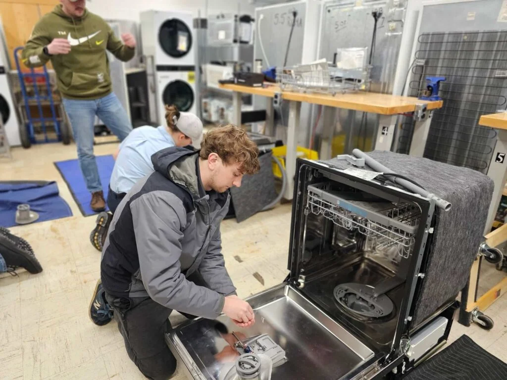 QuickServe Appliance Repairs technician repairing a dishwasher in Abu Dhabi